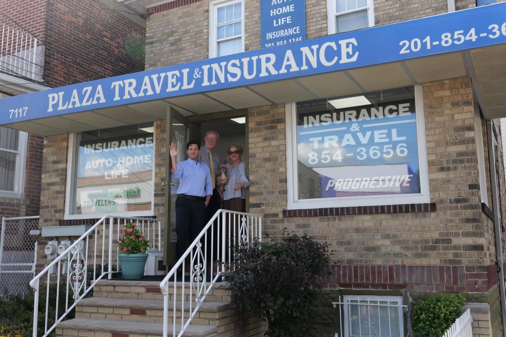 The Plaza Insurance team waving from the office door on Kennedy Boulevard